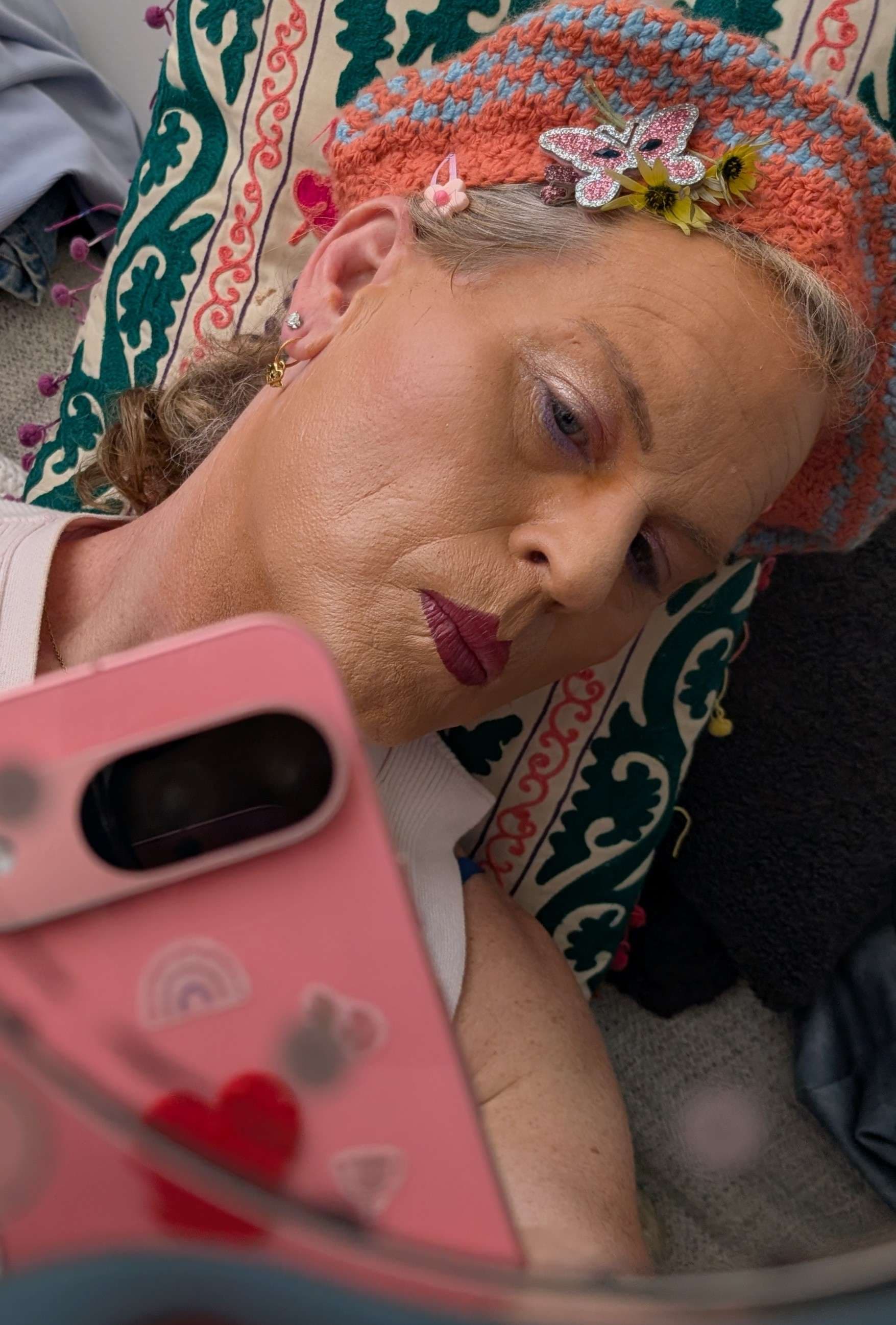 a woman laying on a bed with a phone in her hand